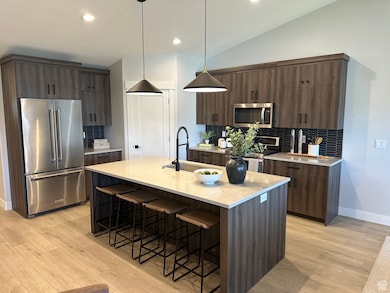 Kitchen featuring decorative backsplash, stainless steel appliances, a breakfast bar, modern cabinets, and recessed lighting
