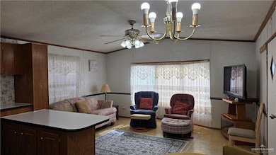 Living area with crown molding, vaulted ceiling, a chandelier, and a textured ceiling