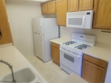 Kitchen featuring stove, fridge, light countertops