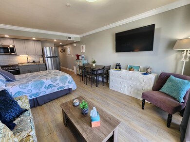 Bedroom with crown molding, freestanding refrigerator, light wood-style flooring, and recessed lighting