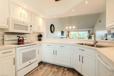 Kitchen featuring white cabinetry, a chandelier, l