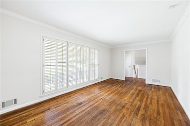 Unfurnished room featuring plenty of natural light, wood finished floors, and crown molding