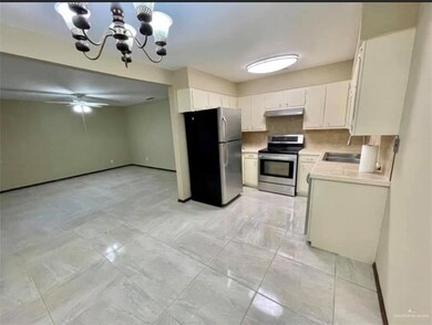 Kitchen with white cabinetry, ceiling fan with notable chandelier, light tile flooring, and stainless steel appliances