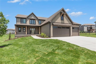 View of front of home with driveway, a garage, covered porch, and board and batten siding