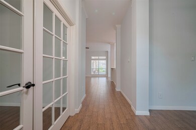 Bright hallway with light walls and wood-look floo