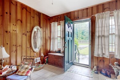 Entrance foyer featuring wooden walls and light tile patterned floors
