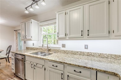 Kitchen with a sink, dishwasher, a textured ceilin