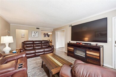 Living room featuring wood-type flooring, crown mo