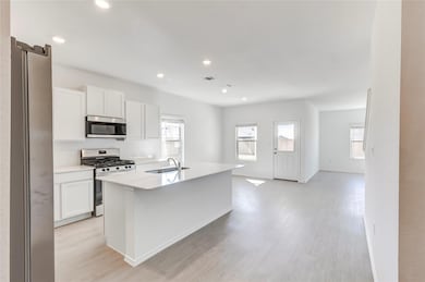 Kitchen featuring stainless steel appliances, white cabinetry, healthy amount of natural light, and recessed lighting