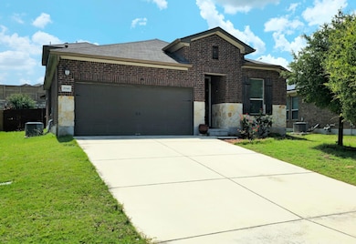 View of front facade with a garage, stone siding,