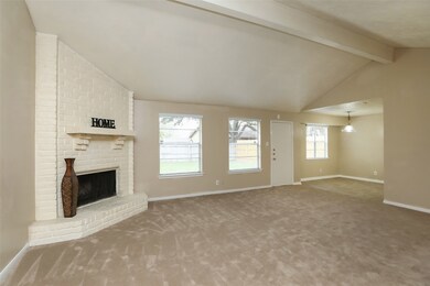 Large family room with corner wood burning fireplace, raised hearth