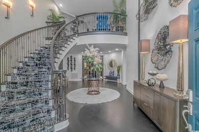 Entryway featuring stairway, a high ceiling, dark wood finished floors, baseboards, and recessed lighting