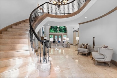 Entrance foyer featuring a towering ceiling, a chandelier, stairs, french doors, and recessed lighting