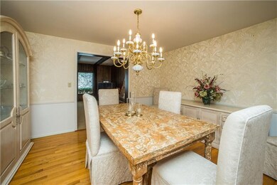Formal dining room with exposed hardwood floor, ch