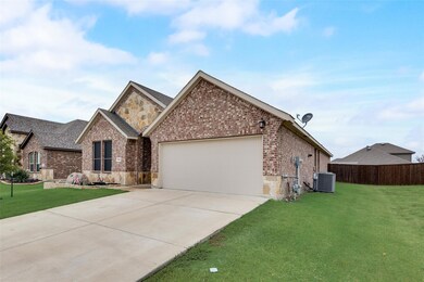 View of front of home featuring a garage, a front yard, and central AC