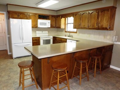 Custom cabinetry, solid surface counters, pantry and spacious breakfast bar are among the amenities of this great kitchen.