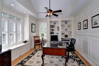The office has great storage in the window seat bench and bookcases. Windows with transoms and plantation shutters along with a vaulted ceiling and views make this a dream place to work.