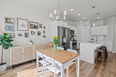 Dining space featuring light wood-style flooring, recessed lighting, and a chandelier