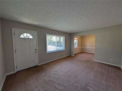 Foyer entrance with visible vents, a textured ceil