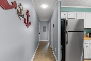 Hallway featuring crown molding, a textured ceilin