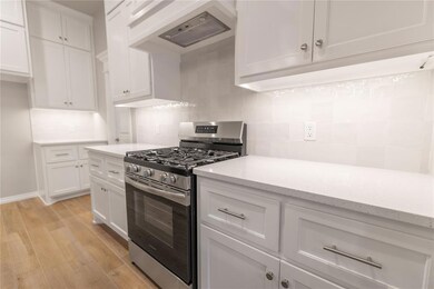 Kitchen featuring white cabinetry, backsplash, and
