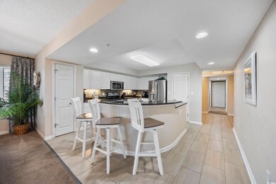Kitchen with a breakfast bar, white cabinets, appliances with stainless steel finishes, a kitchen island, and tasteful backsplash