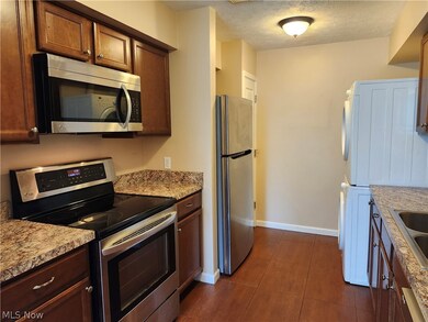 Kitchen featuring light counters, sink, tile floors, stainless steel appliances.