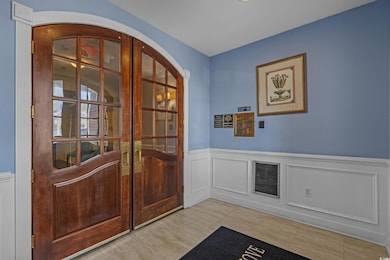 Entrance foyer featuring french doors, a wainscote