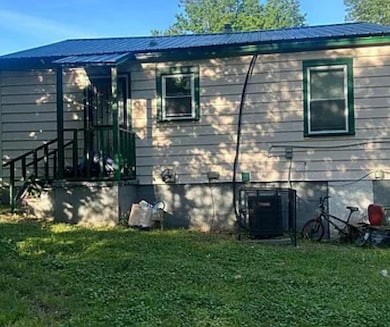 View of home's exterior with a yard and metal roof
