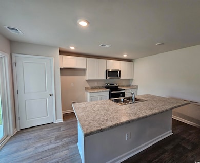 Kitchen with stainless steel appliances, a sink, b