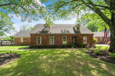 Rear view of property with brick siding, a lawn, f