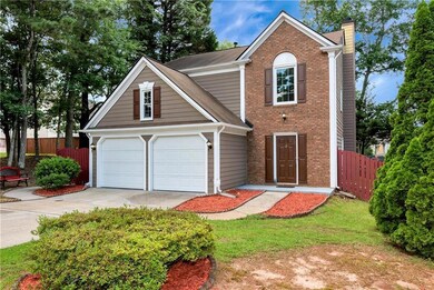 Traditional-style home with a chimney, driveway, a garage, and brick siding