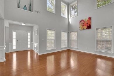 Entryway featuring wood finished floors, plenty of natural light, and a high ceiling