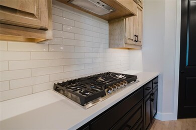 Kitchen featuring light brown cabinets, stainless 