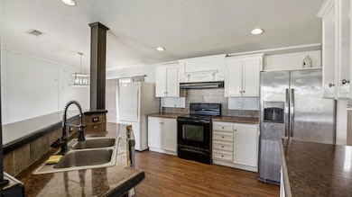 Kitchen featuring stainless steel fridge, dark cou