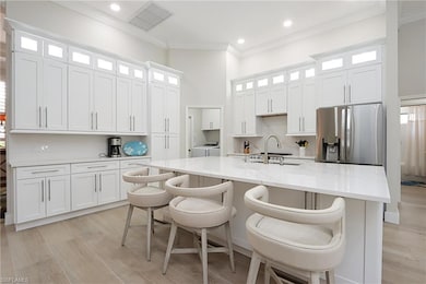 Kitchen featuring stainless steel fridge, white ca