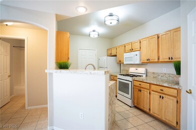 Kitchen with white appliances, light tile patterne
