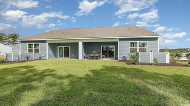 Back of house featuring a lawn and a patio