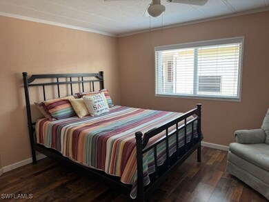 Bedroom featuring a ceiling fan, wood finished flo