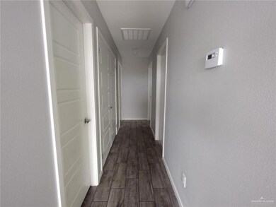 Corridor featuring dark wood finished floors and baseboards