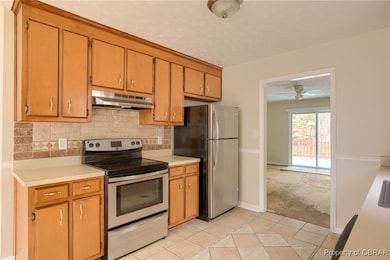 Kitchen with light countertops, tasteful backsplas