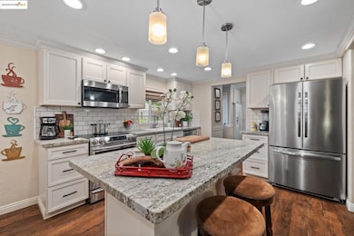 Kitchen with stainless steel appliances, a kitchen island, a breakfast bar area, backsplash, and crown molding