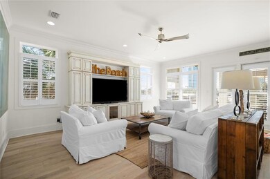 Living room with light wood-type flooring, ceiling fan, and crown molding