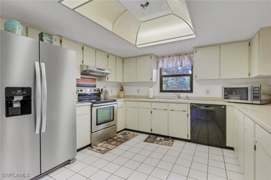 Kitchen featuring appliances with stainless steel finishes, light countertops, light tile patterned floors, cream cabinetry, and under cabinet range hood