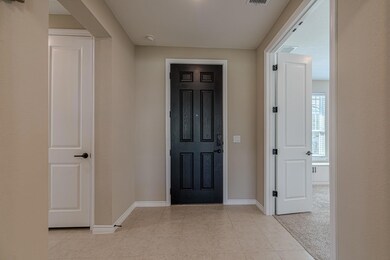 Entrance foyer featuring light tile patterned floors and light carpet