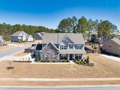 View of front of house with stone siding, fence, a