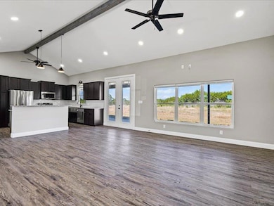 Unfurnished living room featuring ceiling fan, beam ceiling, dark wood finished floors, recessed lighting, and high vaulted ceiling