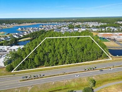 Aerial view of residential area with property boundaries highlighted and a nearby body of water