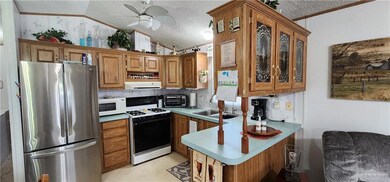 Kitchen featuring a textured ceiling, vaulted ceiling, tasteful backsplash, ceiling fan, and white appliances