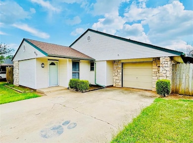 Ranch-style home with concrete driveway, stone siding, and an attached garage